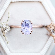 an engagement ring with a blue stone surrounded by flowers