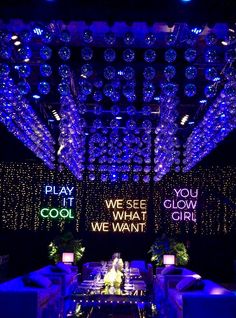 an indoor event with lights and chandeliers hanging from the ceiling, lit up in blue