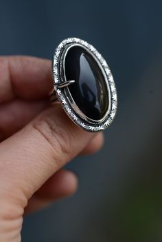 Statement ring with a Black obsidian stone handmade with sterling silver 925. The ring size is 7 US / 54.5 mm At the end I use renaissance wax on my silver piece. So the silver won't tarnish so nearly. Everything in my shop is handmade by myself in my little studio. I put a lot of time and love into my work and I love to be an artist. If you have some questions please send me a message!! Large obsidian ring with solid silver details. The ring size is 54.5 mm / 7 US (diameter 17.5 mm) The ring was made of sterling silver 925. I offer different ring sizes. If you have any questions about ring sizes, please send me a message! I end up using the Renaissance Wax to slow down the oxidation of the silver. I make all of my jewelry in my small workshop. If you still have any questions, please feel Black Obsidian Ring, Big Statement Rings, Black Obsidian Stone, Obsidian Ring, Obsidian Stone, Artisan Rings, Black Obsidian, Silver Pieces, Statement Ring