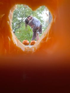 a man and woman are kissing through a hole in a doughnut shaped like a heart