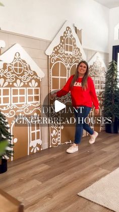 a woman standing in front of a wall with gingerbread houses on it