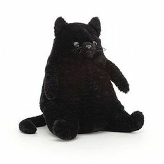 a black cat stuffed animal sitting up against a white background