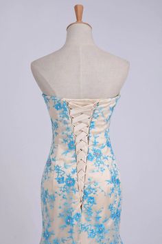 a dress on a mannequin with blue and white floral print in the back