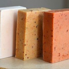 three different types of soaps sitting next to each other on top of a counter