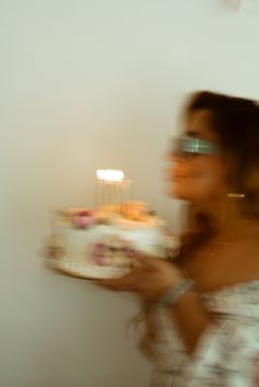 a blurry photo of a woman holding a cake