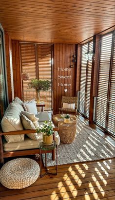 an outdoor living room with wooden walls and flooring is furnished with wicker furniture