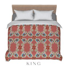 a bed with an orange and blue comforter on top of it next to pillows