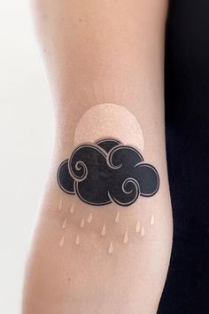 a woman's arm with a cloud and rain tattoo on the left side of her arm