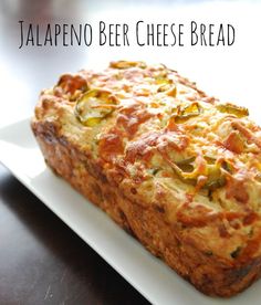 a loaf of jalapeno beer cheese bread sitting on top of a white plate