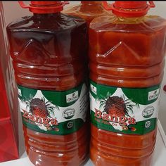 two large jars of tomato sauce sitting on top of a shelf next to each other