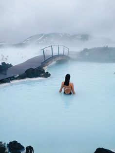 a woman sitting in the middle of a blue lagoon