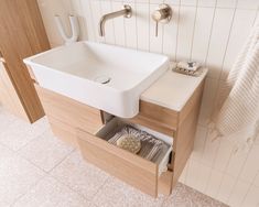 a bathroom sink sitting under a mirror next to a towel rack