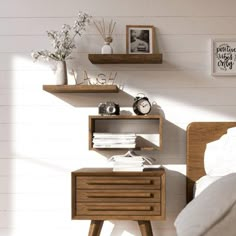 a bed room with a neatly made bed and two wooden shelvings on the wall