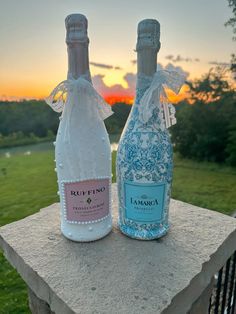 two bottles of wine sitting on top of a stone slab