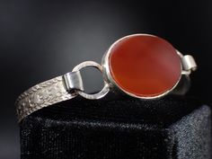 This fabulous antique Etruscan bracelet features an oval carnelian in the center. The setting measures approx. 1" x 3/4". The bracelet measures approx. 6-1/4" inches in circumference x 1/4" up to 3/4" wide. The bracelet is in good pre-owned vintage condition and weighs 9.66 grams. The hook closure is functioning and secure. Items $100 or more are shipped in a high end jewelry presentation gift box. Items less then $100 will be packaged very nicely in a pretty little box, ready for gift giving or Vintage Carnelian Bracelets As Gift, Oval Engraved Carnelian Jewelry, Vintage Carnelian Bracelets Gift, Vintage Carnelian Bracelet Gift, Antique Oval Carnelian Jewelry, Adjustable Nickel-free Carnelian Jewelry, Adjustable Antique Nickel-free Bracelet, Silver Carnelian Hand-strung Jewelry, Adjustable Nickel-free Red Bracelet