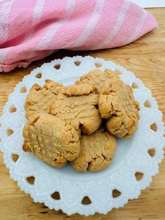 some cookies are on a white plate with a pink towel next to it and a wooden table