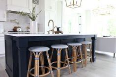 a kitchen island with four stools next to it