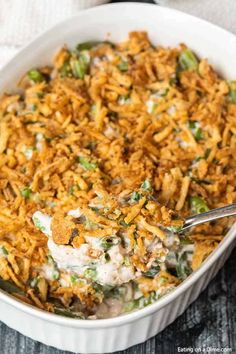 a casserole dish filled with chicken and rice, topped with a spoon in it