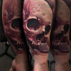 a man's leg with two skulls on it and blood dripping down the side