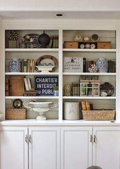 a white bookcase filled with lots of books and other items on top of it