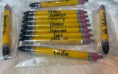 five yellow and black pencils with writing on them sitting in plastic bags next to each other