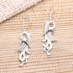 Conjuring a mythical bird Dewa Arimbawa in Bali creates these intriguing dangle earrings. The fanciful winged creatures are crafted from sterling silver and swing from hooks. Unique Silver Jewelry With Bird Design, Silver Dangle Jewelry With Bird Design, Nickel Free Sterling Silver Jewelry In Bird Shape, Silver Bird-shaped Earrings For Pierced Ears, Silver Bird Design Drop Earrings, Elegant Bird Design Drop Earrings, Silver Drop Earrings With Bird Design, Elegant Drop Earrings With Bird Design, Silver Bird-shaped Earrings Gift