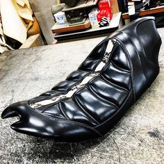 a black leather shoe is sitting on the floor