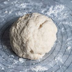 a ball of dough sitting on top of a wire rack in the middle of some flour