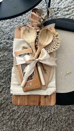 wooden utensils wrapped in white ribbon on top of a table