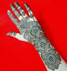 a hand with henna on it sitting on a red surface