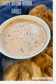 a bowl of soup sitting on top of a blue towel next to fried food items