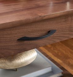 a close up of a drawer with a book on the bottom and a metal handle