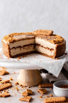 a cake with two slices cut out on a plate and some crackers around it