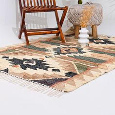 a wooden chair sitting on top of a rug next to a vase filled with flowers