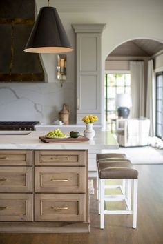 a kitchen with an island and stools in it