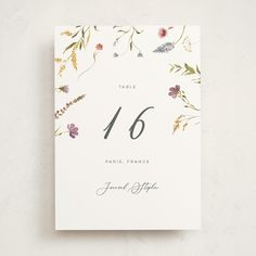 a table number with flowers and leaves on it