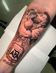 a man's arm with a tattoo on it that has an image of two men kissing