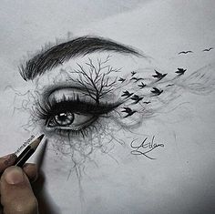 someone drawing an eye with pencils on paper