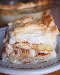 a piece of pie sitting on top of a white plate next to a glass bowl