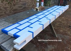 a blue and white bench sitting on top of a wooden table