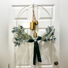 a door with a wreath and bells hanging on it's front door hanger