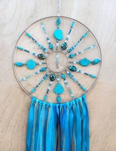 a blue dream catcher hanging on a wooden wall