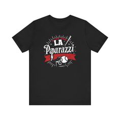 ⚾ Capture the excitement of baseball with our “LA Paparazzi” T-Shirt! This tee features a unique and eye-catching design of the fictional LA Paparazzi baseball team, perfect for fans of the sport. Made from soft, high-quality fabric, it ensures comfort and style for any casual occasion. Whether you’re watching the game or out and about, this shirt is a hit! 🌟 This classic unisex jersey short sleeve tee fits like a well-loved favorite. Soft cotton and quality print make users fall in love with it over and over again. These t-shirts have-ribbed knit collars to bolster shaping. The shoulders are tapered for a better fit over time. Dual side seams hold the garment's shape for longer. .: Made with 100% Airlume combed and ring-spun cotton, a lightweight fabric (4.2 oz/yd² (142 g/m²)) that is ea Black Pre-shrunk Baseball Jersey, Baseball Season Graphic Tee With Logo Print, Black T-shirt With Logo For Baseball Season, Black T-shirt For Baseball Season, Sports Fan Style, Graphic Print Baseball Jersey For Fans, Black Sports Fan T-shirt For Baseball Season, Black Baseball Season T-shirt With Logo Print, Logo Print T-shirt For Baseball Season Streetwear, Sporty Black T-shirt For Baseball Season