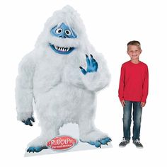 a young boy standing next to a giant white monster