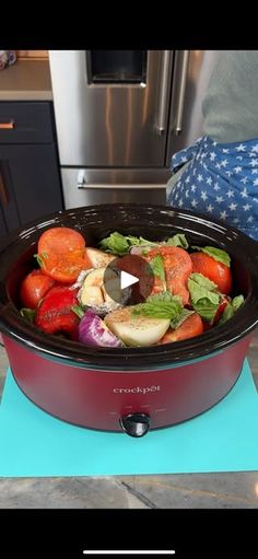 a slow cooker filled with lots of food sitting on top of a blue mat