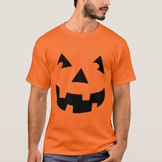 a man wearing an orange t - shirt with a jack o lantern face on it