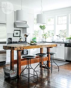 a kitchen island with stools in front of it and an oven on the other side