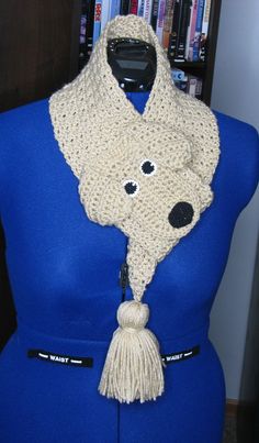 a crocheted dog scarf on a mannequin's head with eyes