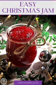 a jar filled with jam sitting on top of a table next to christmas ornaments and decorations