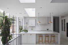 an open kitchen with white cabinets and bar stools